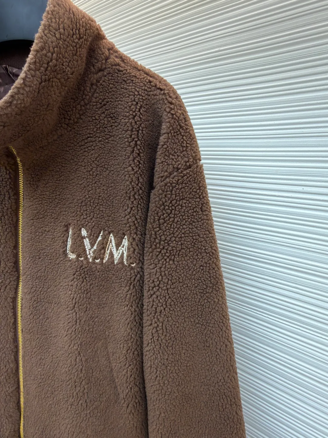 LOUIS VUITTON solid color zipper suede waist long-sleeved velvet jacket ●Original version: Purchased and developed for 17000 ●Item number: 1682255-B50 ●Fabric: cotton fabric ●Technology: Made on positioning cutting machine ●Color: brown ●Version: fitted version ●Weight: about 975 grams ●Size: S-M-L-XL ●Description: This brown lambswool jacket with LVM logo is made of imported imitation lambswool fabric, which has been processed by double carding and shearing processes. The pile length is even to 12mm. It feels fluffy and soft and is not prone to lint and pilling. The bottom layer of the fabric is compounded with waterproof polyester lining, which is seamlessly bonded through a heat-pressing lamination process, effectively locking in temperature and preventing linting. The body adopts a loose shoulder-drop design, and the three-dimensional tailoring technology allows the shoulders and body to connect naturally without any stiff splicing. The front is equipped with a customized brass zipper, which has been treated with electroplating and anti-oxidation, making it smooth and durable. The LVM logo on the left chest is made of three-dimensional embroidery technology, using high-twist cotton thread and flat embroidery stitching. The stitching is dense and does not skip stitches. The ribbed edges on the neckline and hem are made of spandex blended material, which has been pre-shrunk and has long-lasting elasticity without sagging. The overall seams use dual hemming and overlocking techniques, with 11 stitches per inch, taking into account the firmness of the fit and durability. The overall wiring is straight and delicate, the fabric is comfortable and soft, and the color is consistent without color difference. It can be matched with the same style to create a fashionable look and control various occasions. Customized accessories, complete with three standards, same style for men and women!